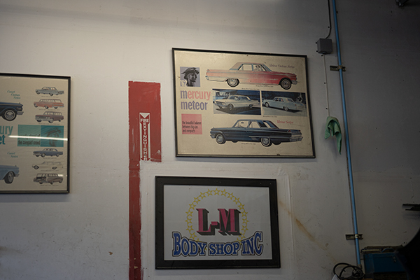 Classic car posters and the original L-M Body Shop sign inside the shop